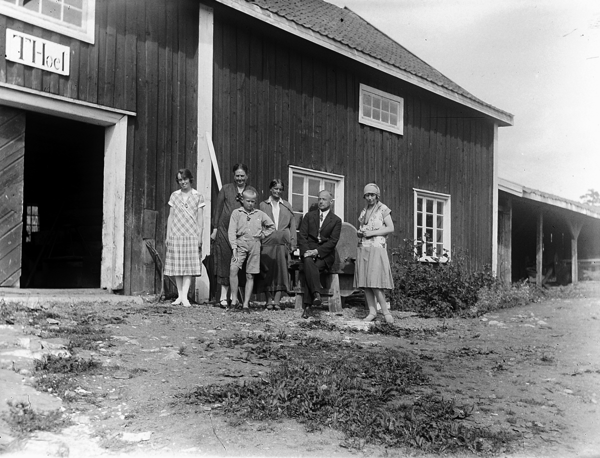 Familiegruppe på tunet foran stabburet på Hovinsholm, Helgøya.