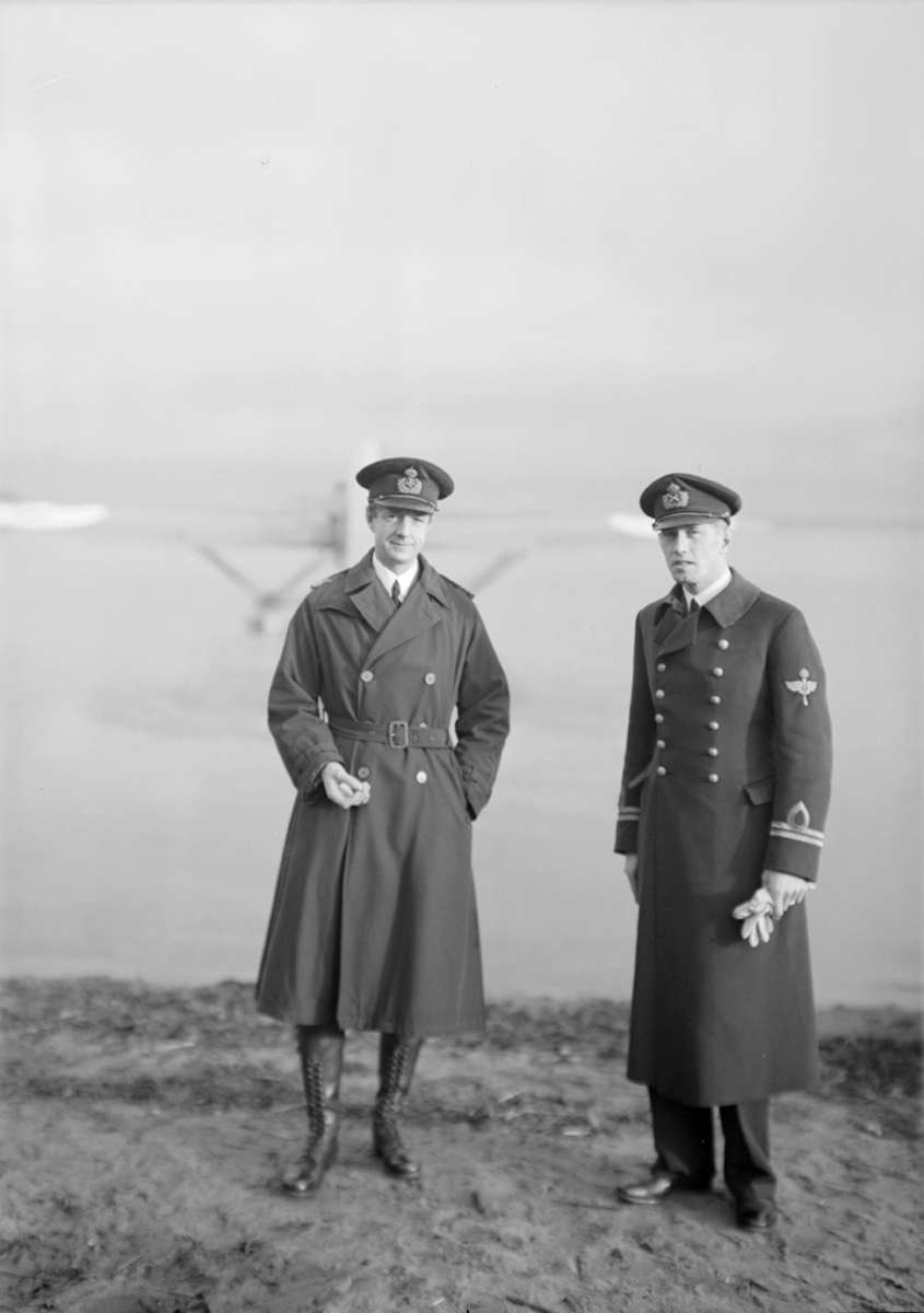 Porträtt av kapten Tornberg och löjtnant Holmér. Ett flygplan syns i bakgrunden.