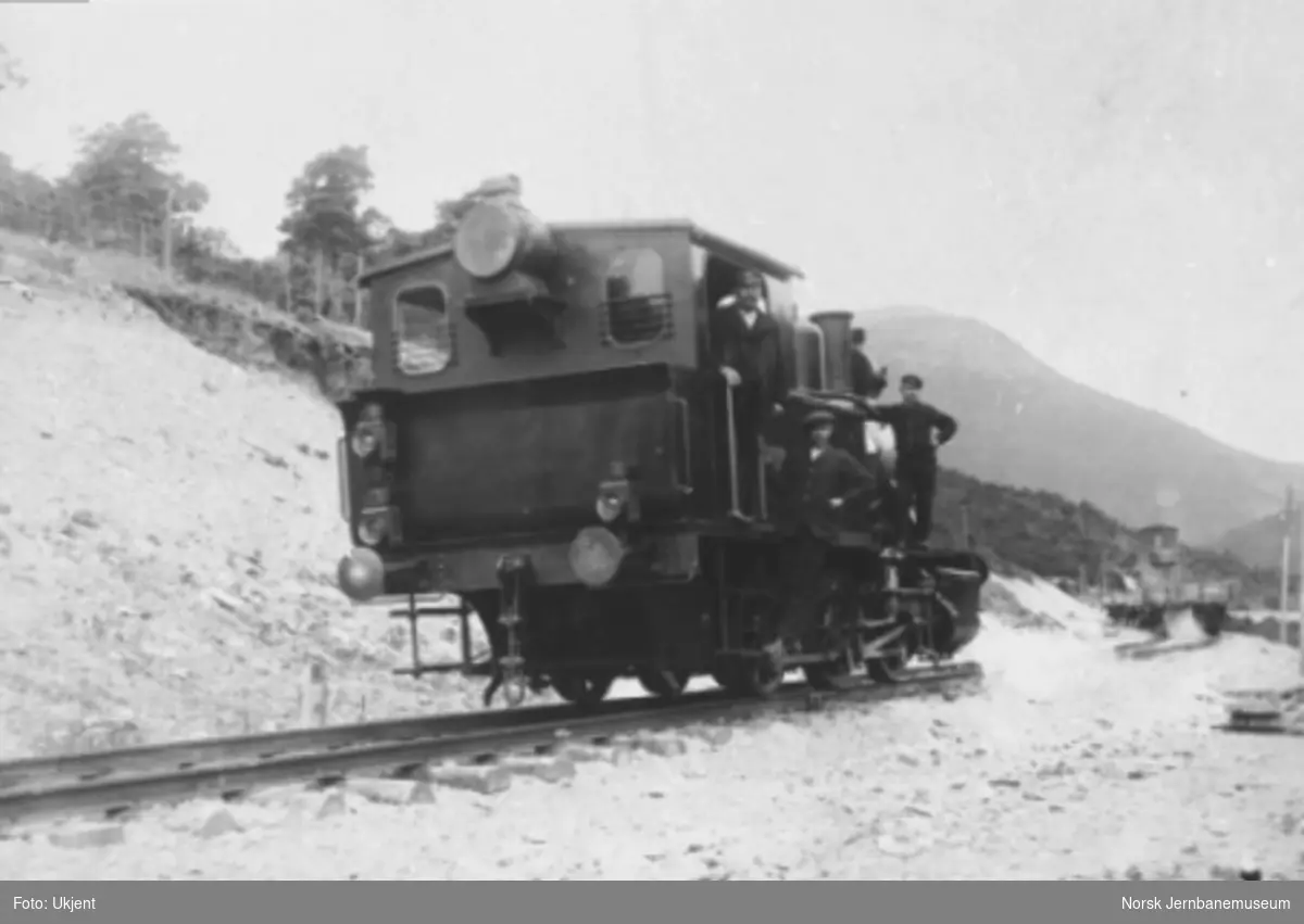 Damplokomotiv type 25a med tre mann på lokomotivet under grusing nord for Otta