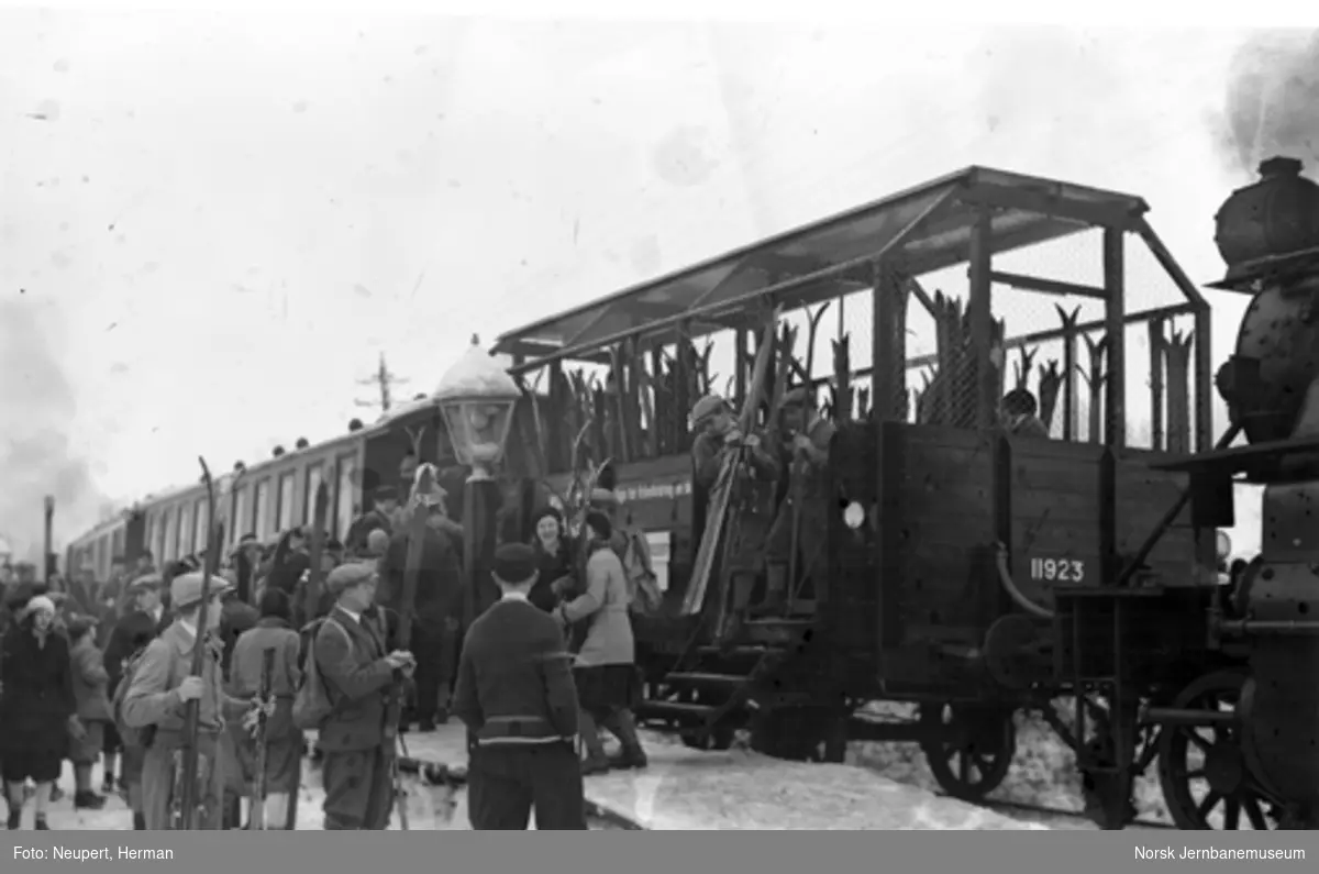 Persontog og skiturister på ukjent stasjon, forende av tanklok type 34 i bildekanten
