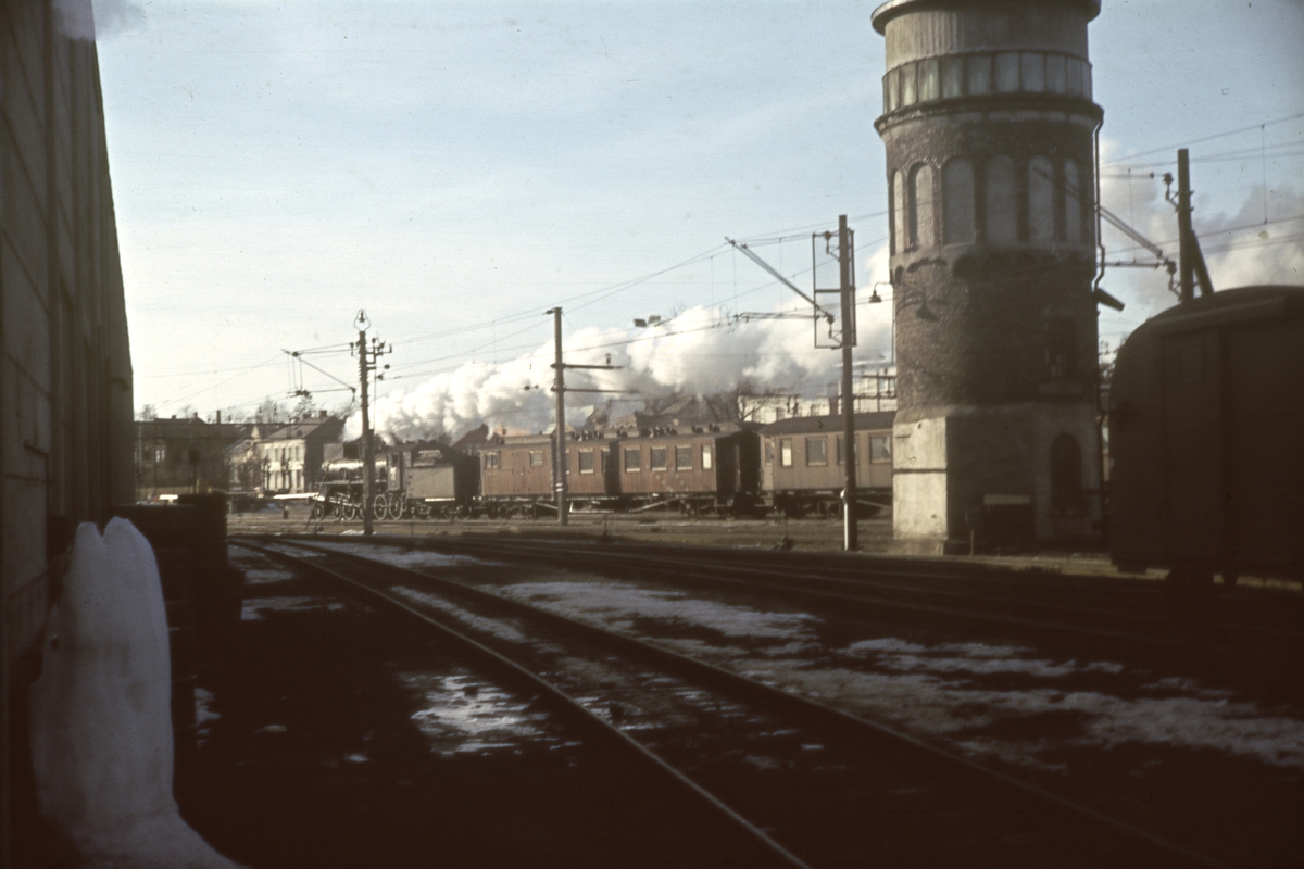 Damplokomotiv type 26 med tog fra Rørosbanen ankommer Hamar stasjon