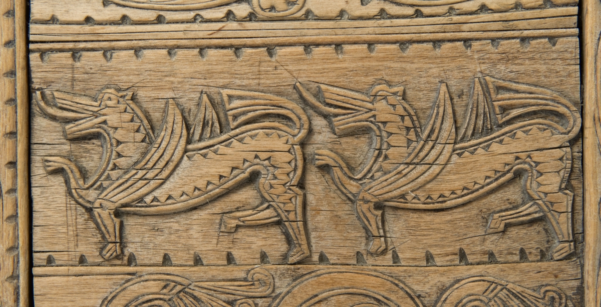 Fire søyler med skåret dyrehode-ornamentikk, sammenføyet med tverrbord og fyllinger. Bunn er åpen foruten to tverrstaver. Hele utsiden er rikt dekorert med utskåret dyr og ranker.