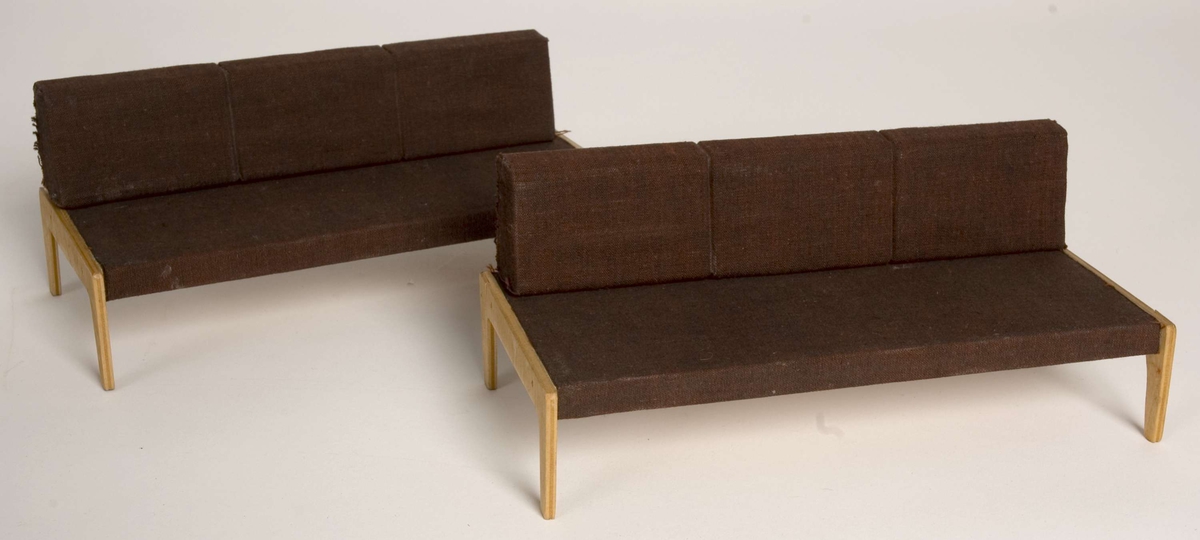 Modellen av sovesofaen består av: sengebunn og løse (sammensittende)  ryggputer av tre, trukket med rødbrunt tekstiltrekk.
