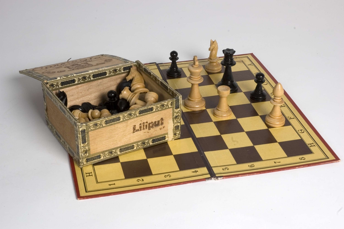 Sjakkspill med brett (A) og 16 svarte og 16 lyse brikker (B) i sigareske (C).