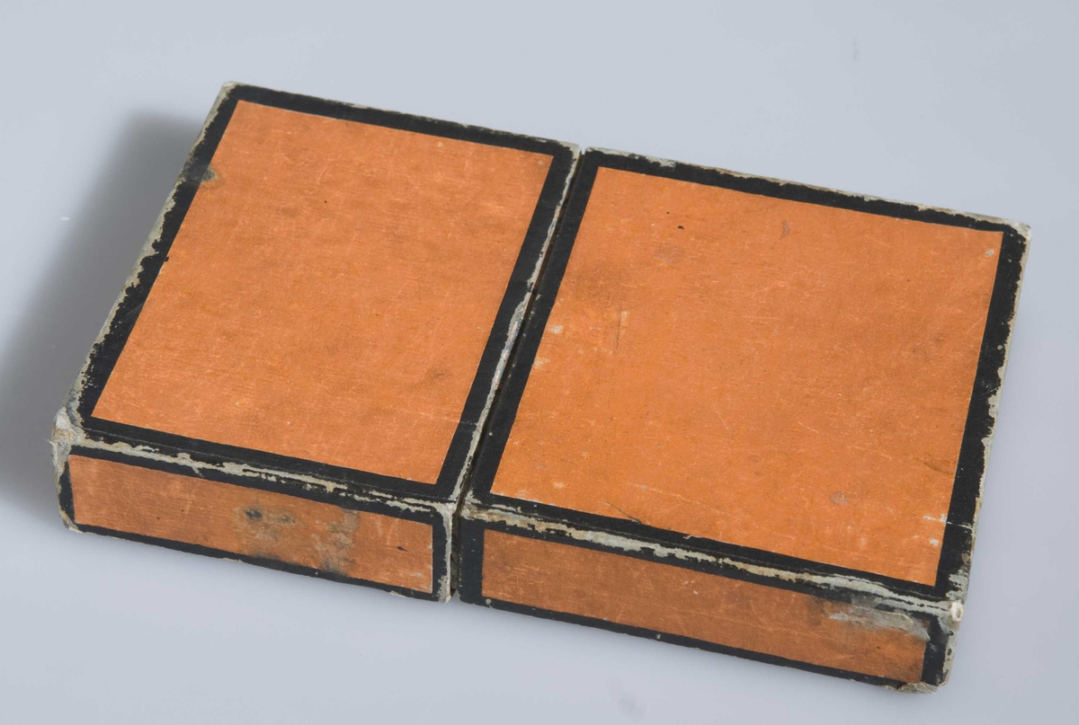 Løse ark med gullsnitt i skinnperm, ligger i futteral av kartong. Håndskrevet tekst.