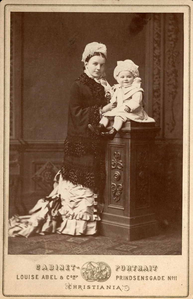 Kvinnen på bildet er etter all sannsynlighet Hanna Andresen Butenschøn, født Døderlein 12. juli 1851. Hun var forfatter under pseudonymet Helene Dickmar. Barnet er Hans Barthold Butenschøn Andresen, mai 1879. Portrett av mor med barn.
