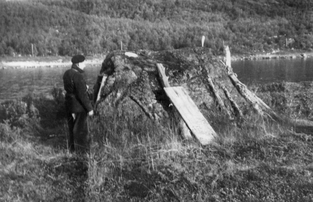 Fjøsgamme med en person utenfor, elven i bakgrunnen, Guorzam - Polmak 1952.