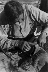 En mann jobber med et neversøkk til garn. Nuorgam 1948.