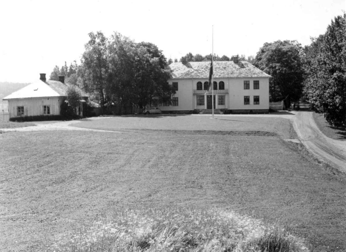 Haugrim, Aurskog, Akershus 1954. Hovedhuset med flagg på halv stang og sidebygning.
Fra dr. Eivind S. Engelstads storgårdsundersøkelser 1954.