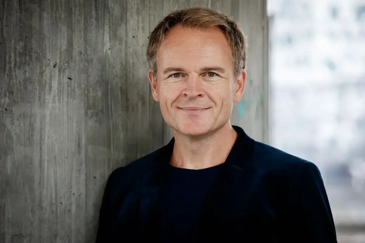 Portrettfoto av Thor Magnus Tangerås framom ein betongmur