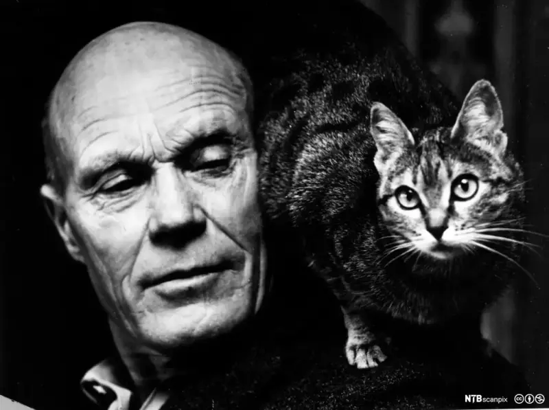 Portrett av Tarjei Vesaas i svart kvitt med ein katt på skuldra.