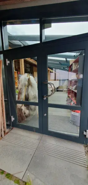 Sideinngang til museumsbutikk og resepsjon. Dobbeldør i glas og metall, 180 cm brei.